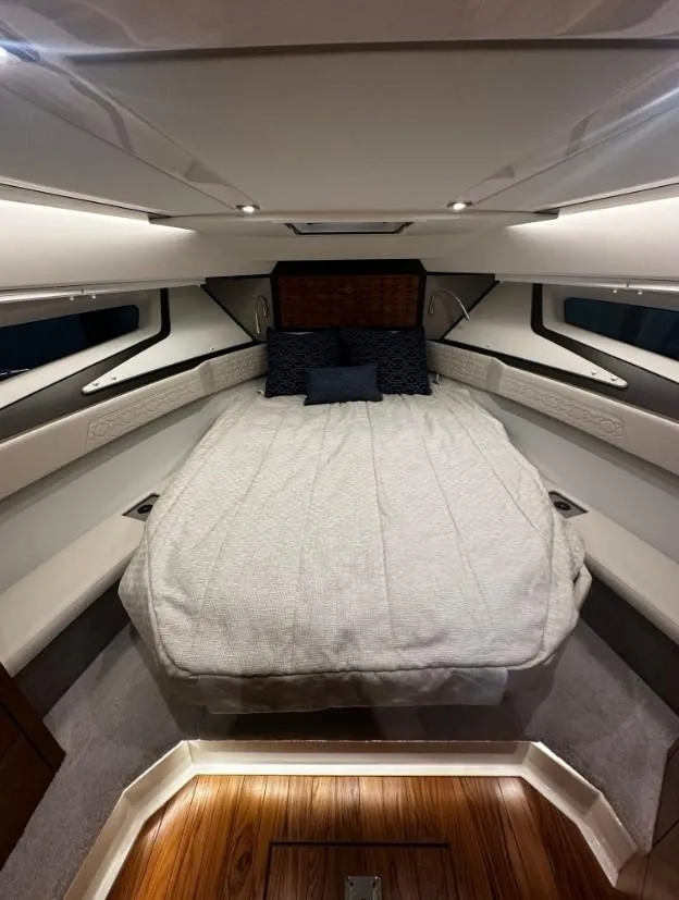 Slide: The Image of 2023 Tiara Yachts 43 LE cabin interior with luxurious bedding and ambient lighting. - 4