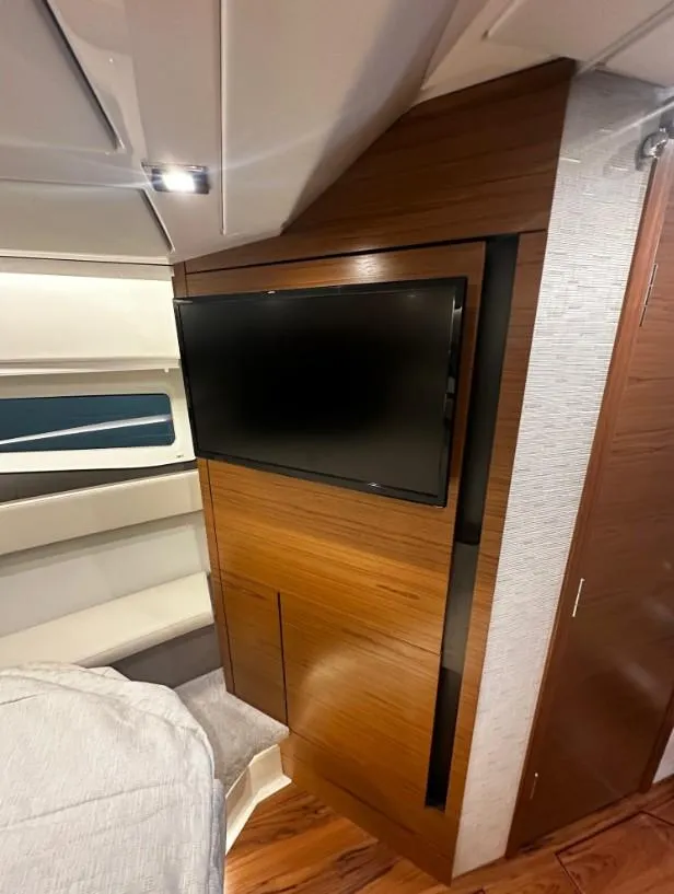 Slide: The Image of Interior of 2023 Tiara Yachts 43 LE featuring a sleek wooden panel with a mounted TV. - 5