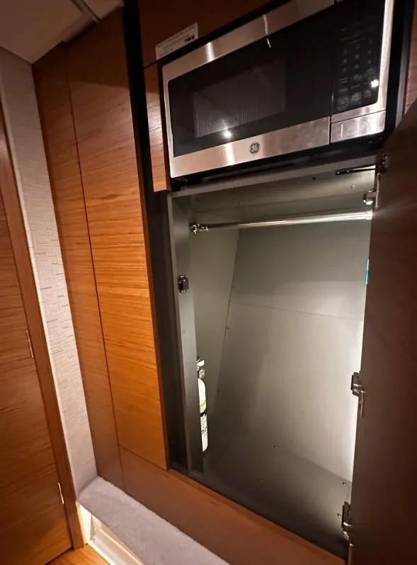 Slide: The Image of 2023 Tiara Yachts 43 LE interior with built-in microwave and storage space. - 8