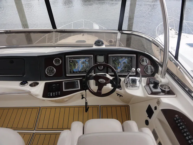 Slide: The Image of 2009 Meridian 441 Sedan helm with navigation screens and controls, docked by the water. - 10