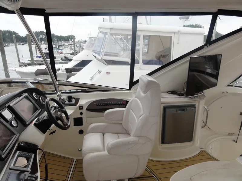 Slide: The Image of Interior of 2009 Meridian 441 Sedan yacht with helm, seating, and marina view. - 12