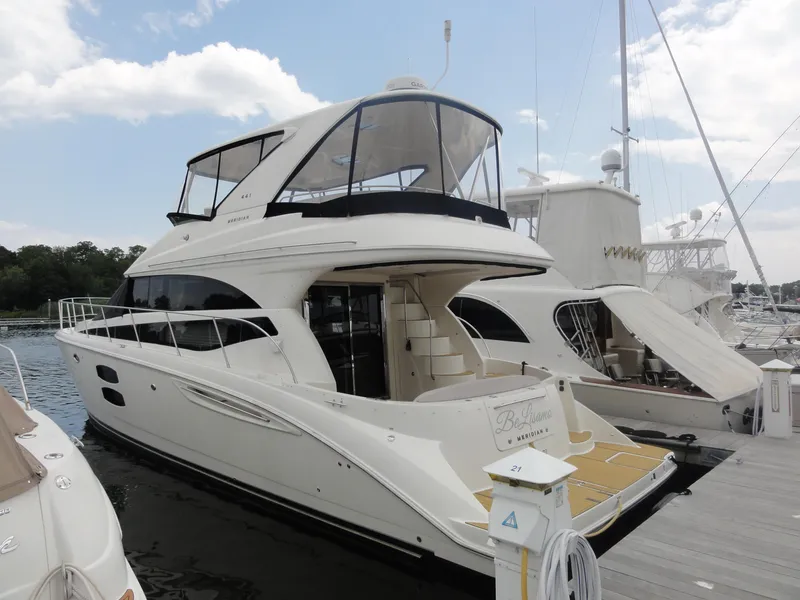 Slide: The Image of 2009 Meridian 441 Sedan yacht docked at marina, featuring sleek design and spacious upper deck. - 4
