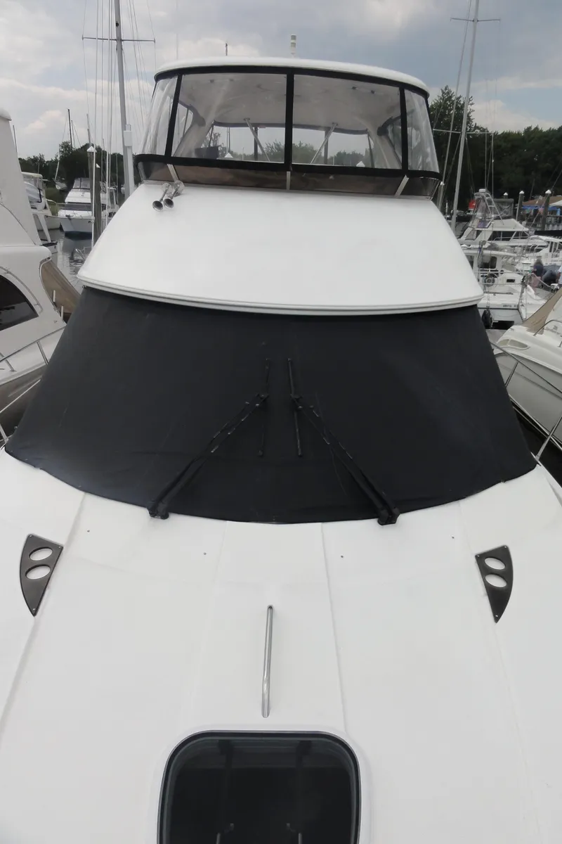 Slide: The Image of 2009 Meridian 441 Sedan yacht docked at marina, front view with covered windshield. - 7