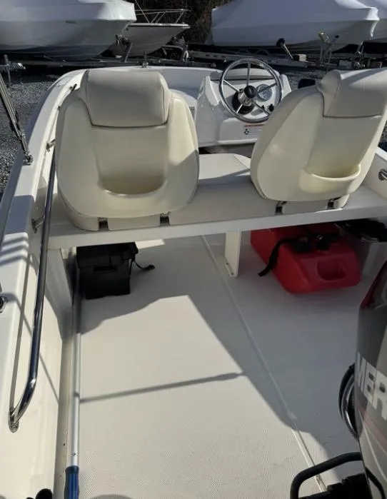 Slide: The Image of 2024 Boston Whaler 130 Super Sport interior with dual seats and steering wheel. - 16
