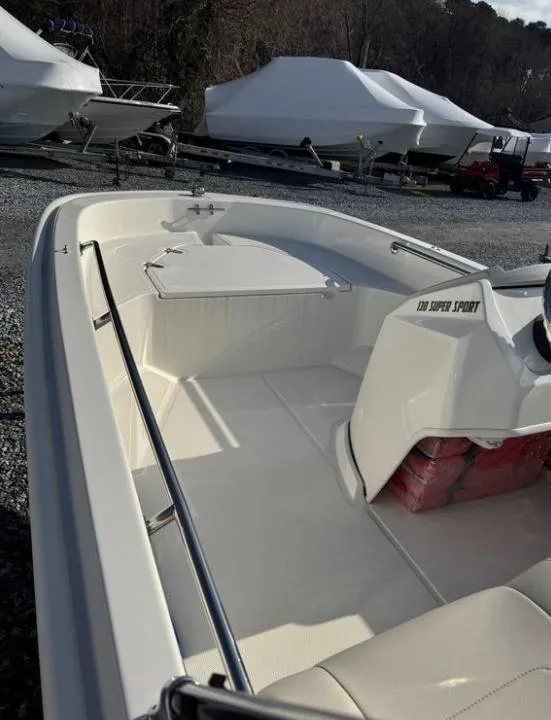 Slide: The Image of 2024 Boston Whaler 130 Super Sport boat, white interior, parked outdoors. - 17