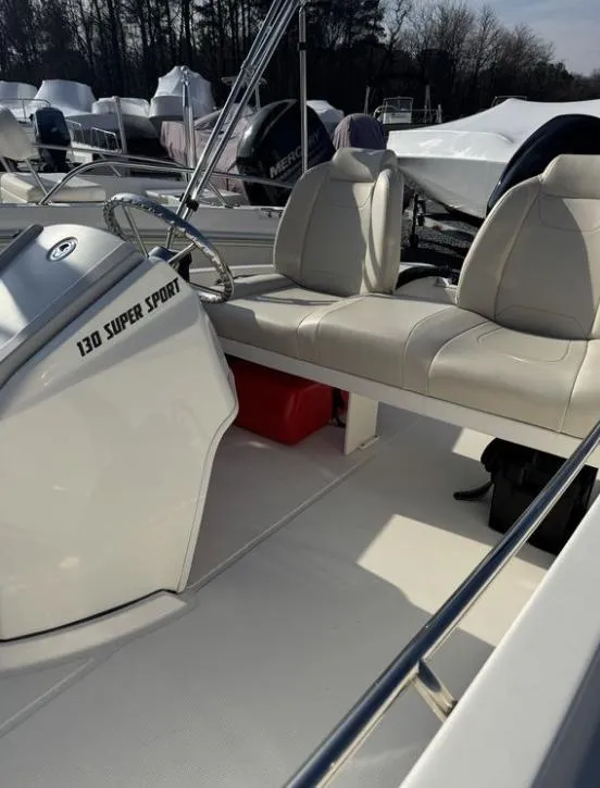 Slide: The Image of 2024 Boston Whaler 130 Super Sport boat interior with seating and steering wheel. - 19