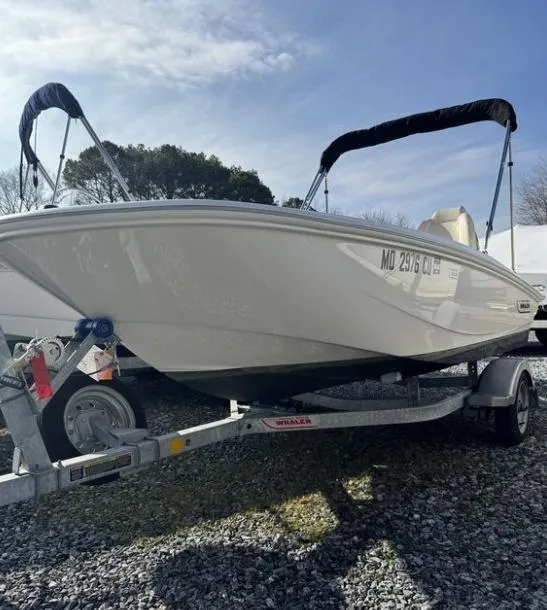 Slide: The Image of 2024 Boston Whaler 130 Super Sport boat on trailer, parked outdoors. - 21