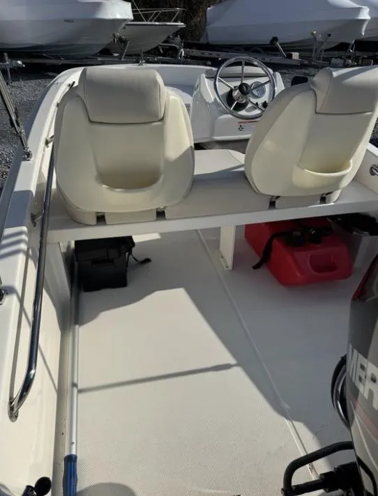 Slide: The Image of 2024 Boston Whaler 130 Super Sport interior with seating and steering wheel. - 22