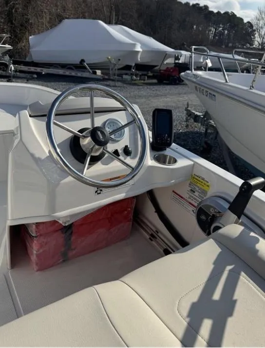 Slide: The Image of 2024 Boston Whaler 130 Super Sport boat interior with steering wheel and control panel. - 24