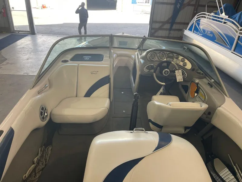 Slide: The Image of 2006 Nautique Ski 206 boat interior with white and blue seating, dashboard, and steering wheel. - 17