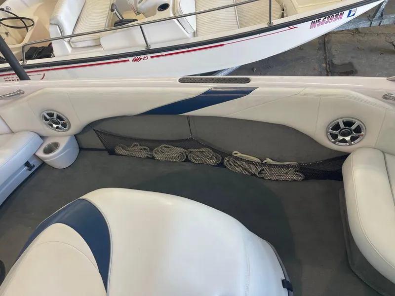 Slide: The Image of 2006 Nautique Ski 206 boat interior with white and blue seating and storage netting. - 25