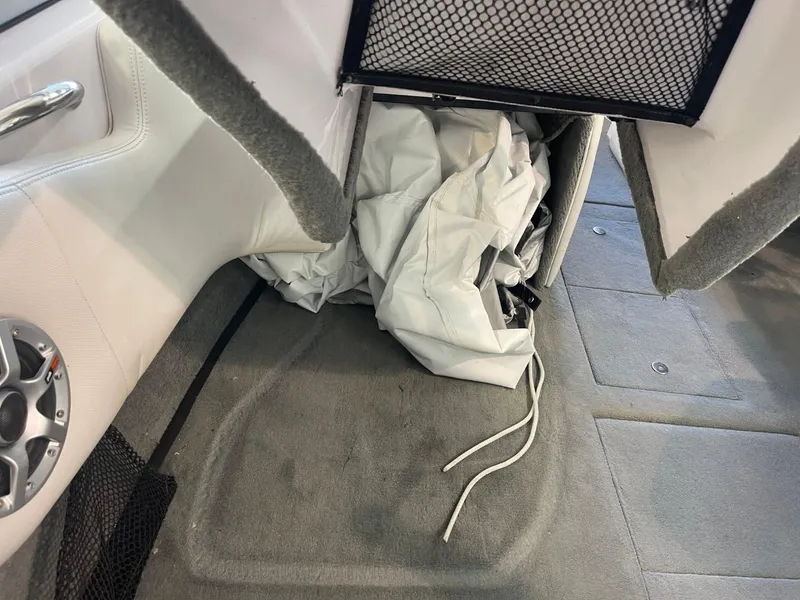 Slide: The Image of 2006 Nautique Ski 206 interior showing storage compartment with white fabric and speaker. - 28