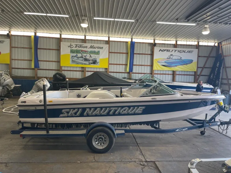 Slide: The Image of 2006 Nautique Ski 206 boat in showroom, blue and white design, on trailer. - 3