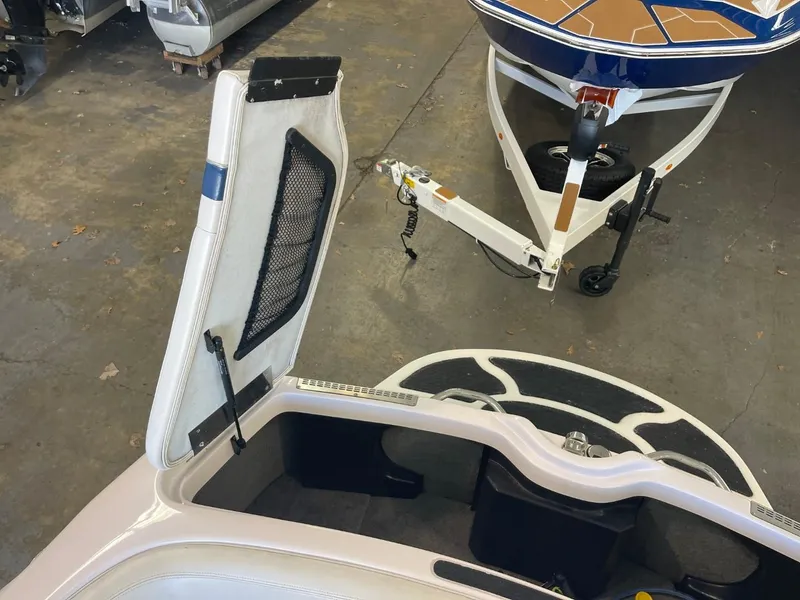 Slide: The Image of 2006 Nautique Ski 206 boat interior with open storage compartment and trailer. - 31