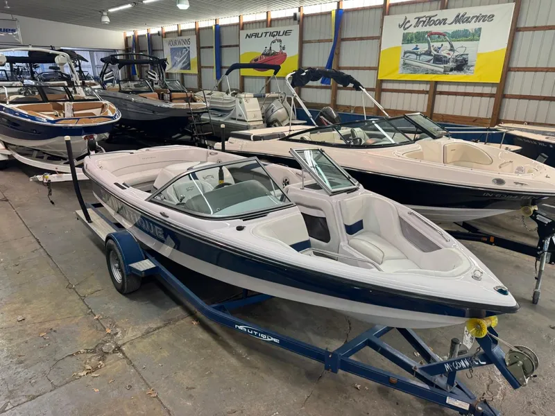 Slide: The Image of 2006 Nautique Ski 206 boat in showroom, surrounded by other boats. - 39