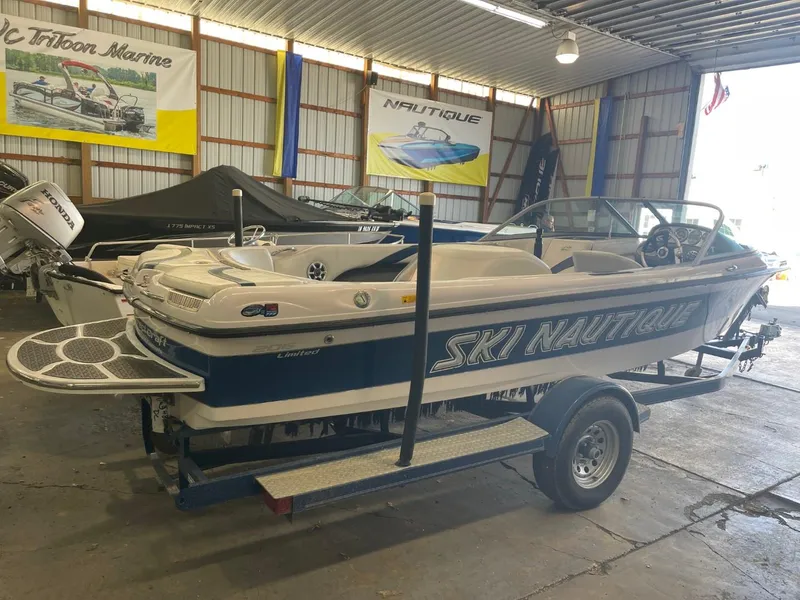 Slide: The Image of 2006 Nautique Ski 206 boat in a showroom, featuring sleek design and trailer. - 4