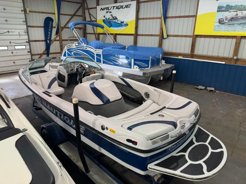 Slide: The Image of 2006 Nautique Ski 206 boat in showroom, featuring sleek design and blue accents. - 41