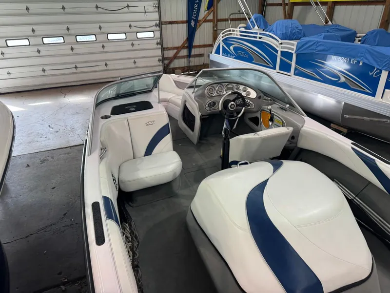 Slide: The Image of 2006 Nautique Ski 206 boat interior with white and blue seating in a garage. - 42