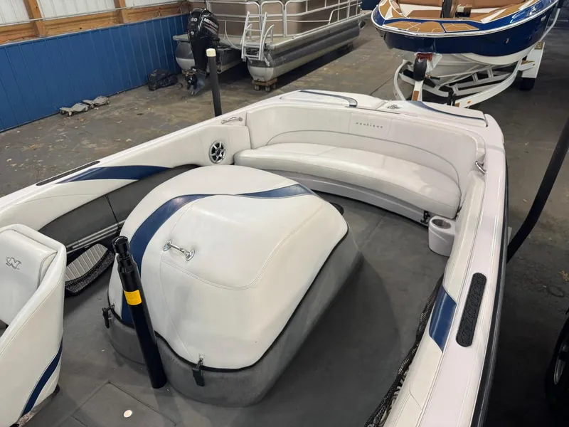 Slide: The Image of 2006 Nautique Ski 206 boat interior with white and blue seating in a showroom. - 44