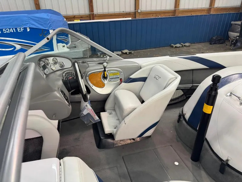 Slide: The Image of 2006 Nautique Ski 206 boat interior with steering wheel and seating in a storage facility. - 45