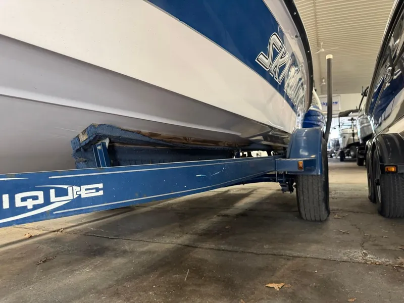Slide: The Image of 2006 Nautique Ski 206 boat on trailer, blue and white, parked indoors. - 48
