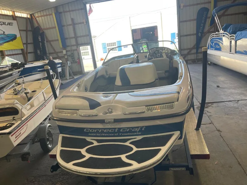 Slide: The Image of 2006 Nautique Ski 206 boat in a showroom, rear view with interior seating visible. - 5