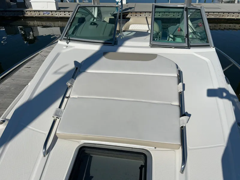 Slide: The Image of 2014 Chaparral 310 Signature boat with sunpad on deck, docked at marina. - 12