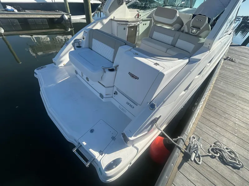 Slide: The Image of 2014 Chaparral 310 Signature Axis boat docked, featuring spacious seating and swim platform. - 13