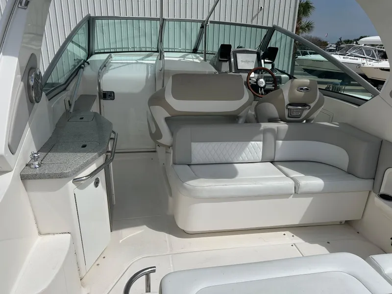 Slide: The Image of 2014 Chaparral 310 Signature boat interior with seating and helm, featuring modern design. - 14