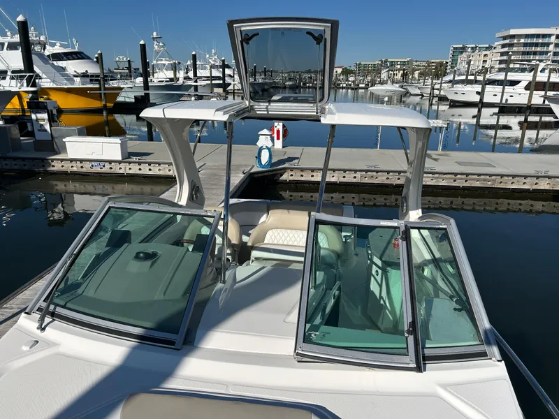 Slide: The Image of 2014 Chaparral 310 Signature Axis boat docked at a marina with clear blue skies. - 23