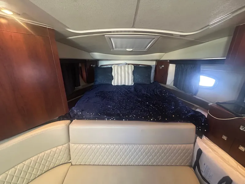 Slide: The Image of 2014 Chaparral 310 Signature cabin interior with bed and seating area. - 27