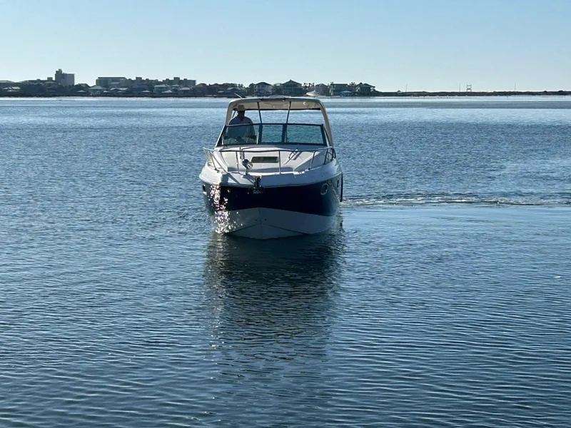 Slide: The Image of 2014 Chaparral 310 Signature Axis boat cruising on calm water. - 7