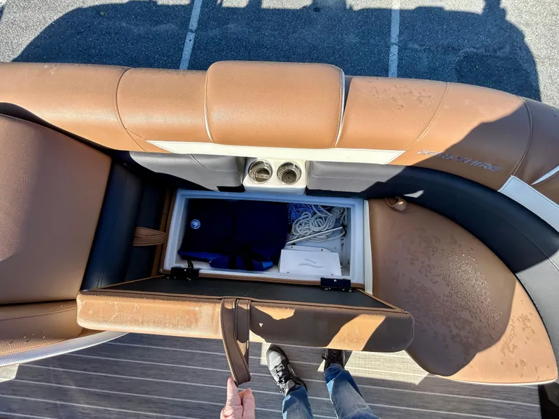 Slide: The Image of 2021 Berkshire 25RFX DC STS 3.0+ boat storage compartment with brown seating and cup holders. - 10