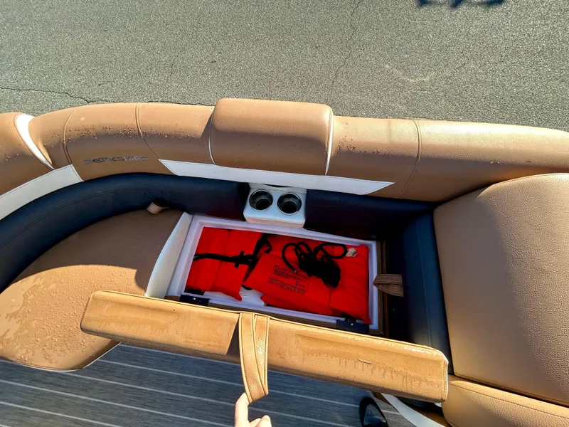 Slide: The Image of 2021 Berkshire 25RFX DC STS 3.0+ boat seat storage with cup holders and red life jacket. - 12