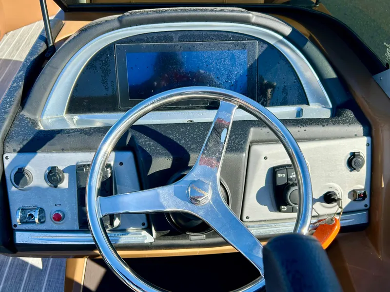 Slide: The Image of 2021 Berkshire 25RFX DC STS 3.0+ boat dashboard with steering wheel and control panel. - 19
