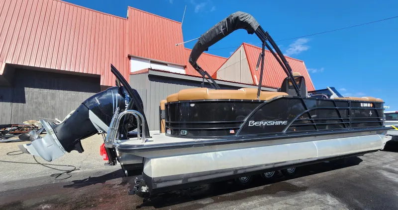 Slide: The Image of 2021 Berkshire 25RFX DC STS 3.0+ pontoon boat with outboard motor, docked outdoors. - 2