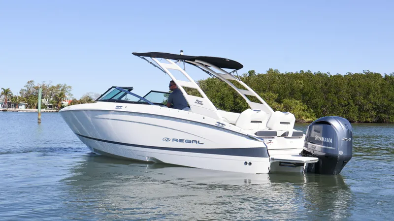Slide: The Image of 2022 Regal LX4 boat cruising on calm water with Yamaha outboard motor. - 0