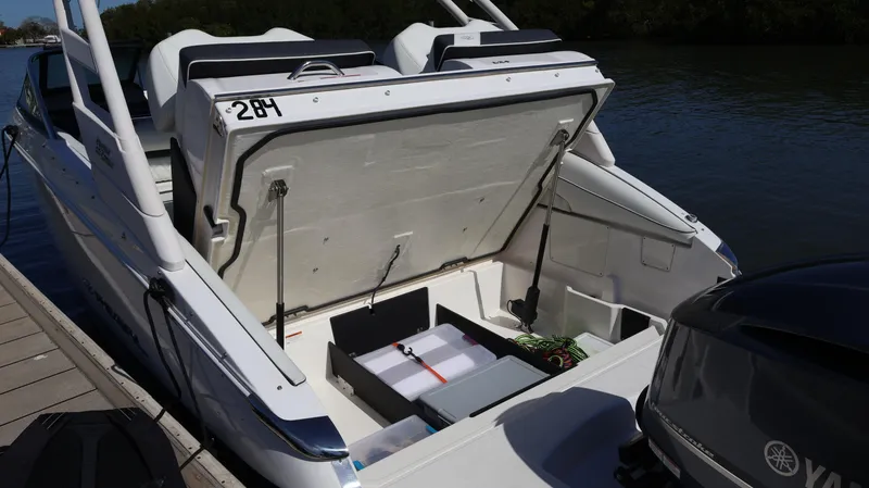 Slide: The Image of 2022 Regal LX4 boat with open storage compartment, docked by the water. - 15
