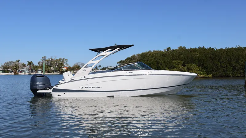 Slide: The Image of 2022 Regal LX4 boat on calm water, clear sky background. - 2