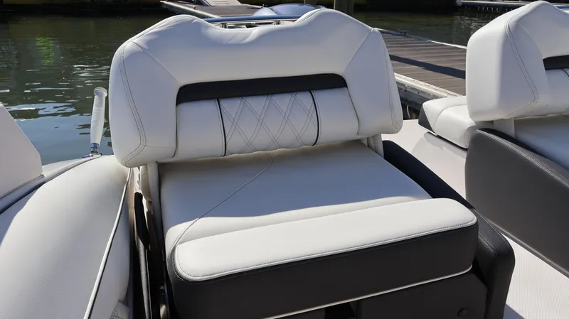 Slide: The Image of 2022 Regal LX4 boat seat with white and black upholstery by the water. - 23