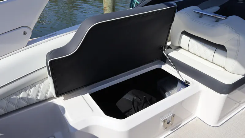 Slide: The Image of Open storage compartment in a 2022 Regal LX4 boat, featuring cushioned seating. - 30