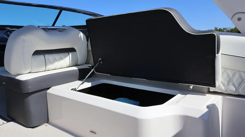 Slide: The Image of 2022 Regal LX4 boat interior with open storage compartment and cushioned seating. - 37