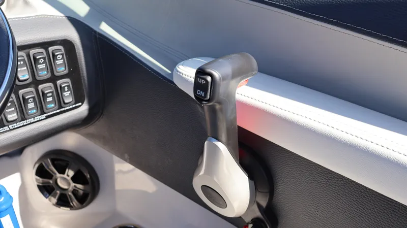Slide: The Image of Throttle control lever in a 2022 Regal LX4 boat cockpit. - 44
