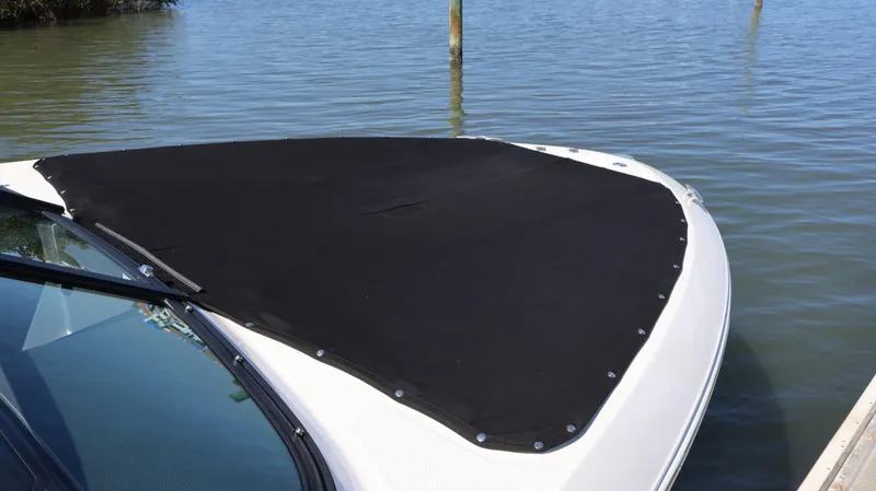 Slide: The Image of 2022 Regal LX4 boat with black cover on water. - 6