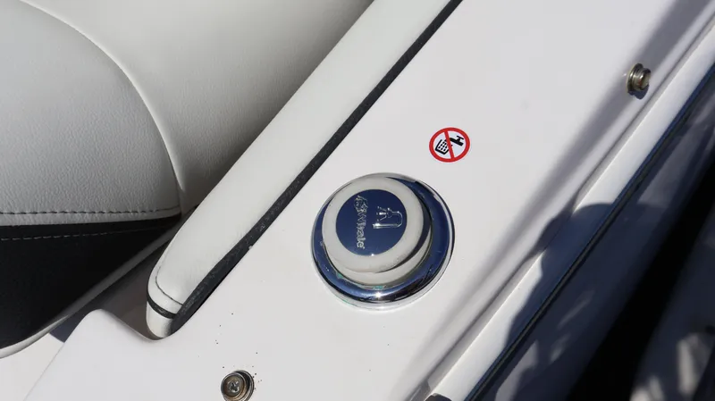 Slide: The Image of Close-up of 2022 Regal LX4 boat interior with a button and warning sticker. - 8
