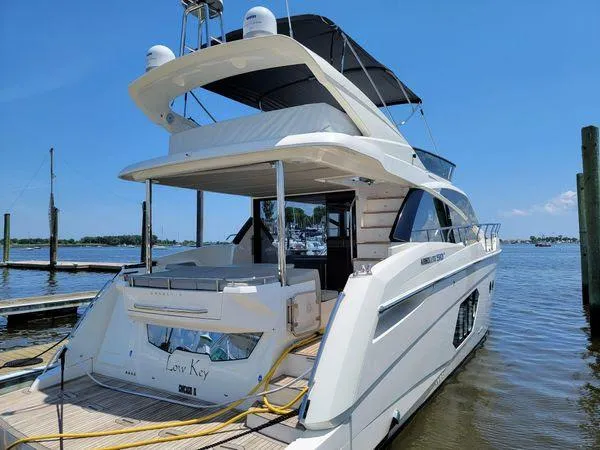 Slide: The Image of 2019 Absolute 50 Fly yacht docked at marina under clear blue sky. - 2