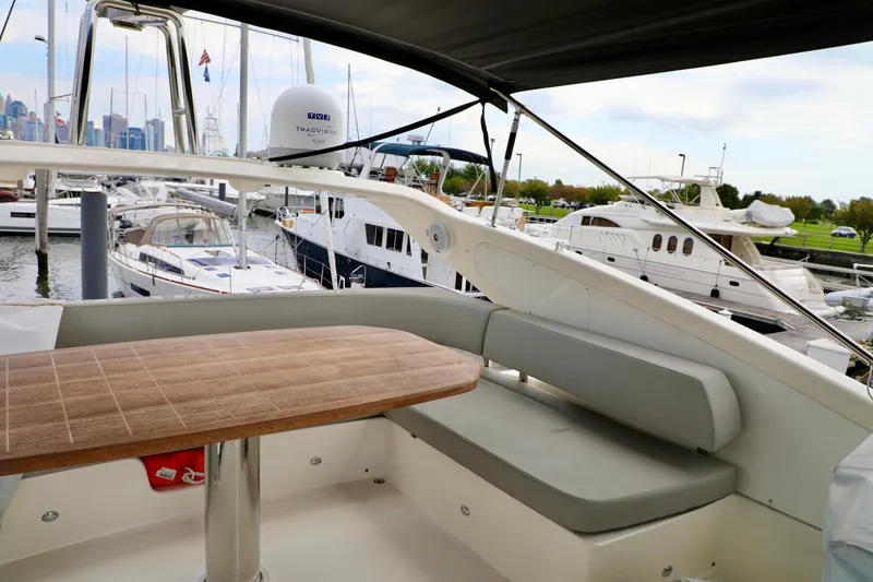 Slide: The Image of Flybridge seating area on 2019 Absolute 50 Fly yacht, docked with other boats in marina. - 21