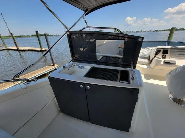 Slide: The Image of Outdoor kitchen on 2019 Absolute 50 Fly yacht with grill and sink, docked by the water. - 25