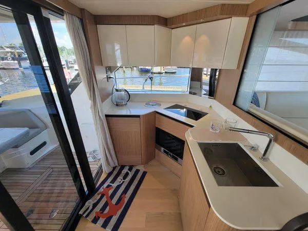 Slide: The Image of Modern kitchen interior on 2019 Absolute 50 Fly yacht, featuring sleek design and marina view. - 29