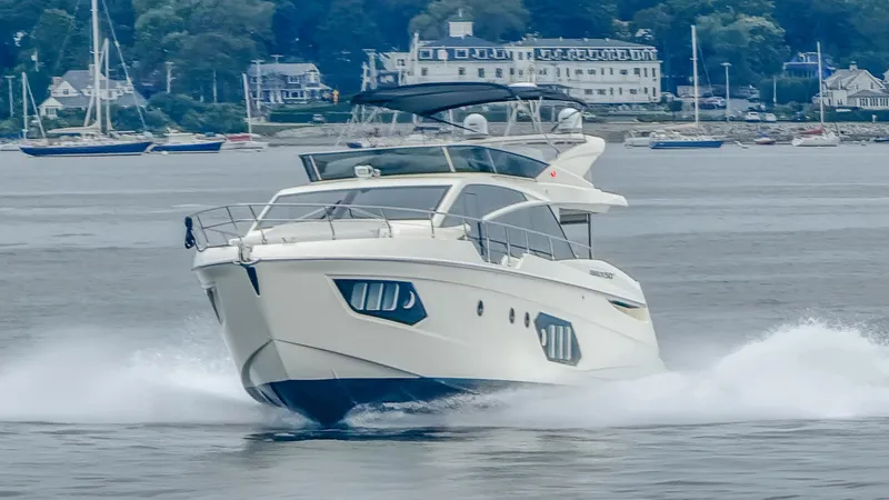 Slide: The Image of 2019 Absolute 50 Fly yacht cruising on water with scenic coastal background. - 4